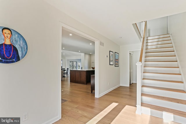 interior space featuring recessed lighting, visible vents, light wood-style floors, baseboards, and stairs