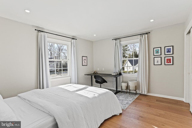 bedroom with light wood-style floors, baseboards, and recessed lighting