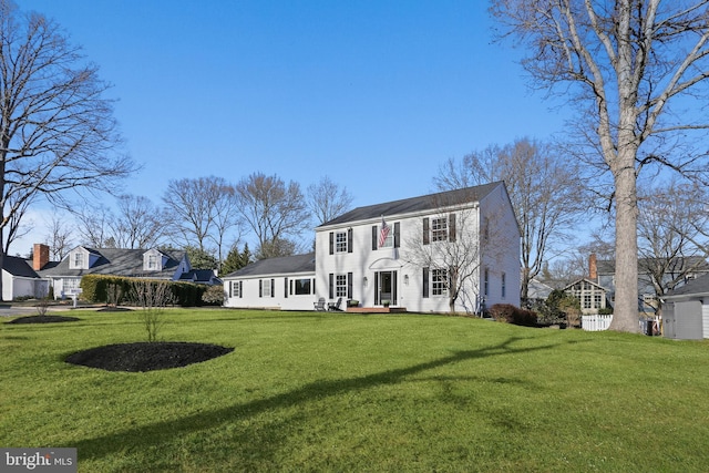 colonial home featuring a front lawn