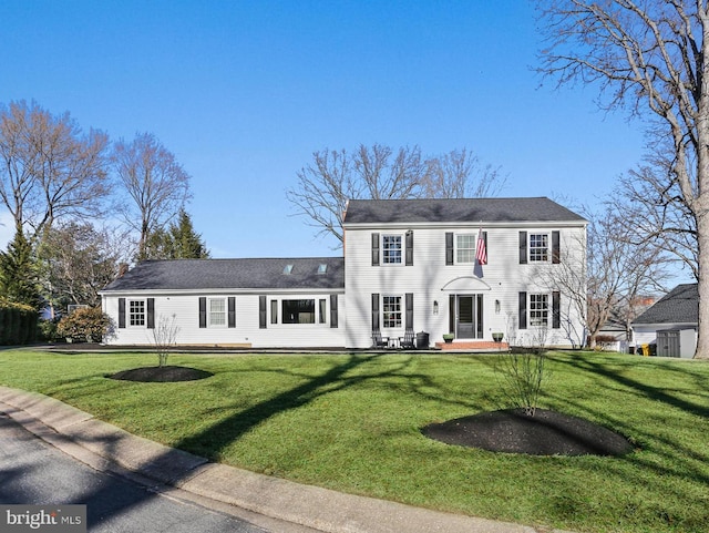 colonial house featuring a patio area and a front yard