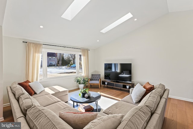 living room with lofted ceiling with skylight, recessed lighting, baseboards, and wood finished floors