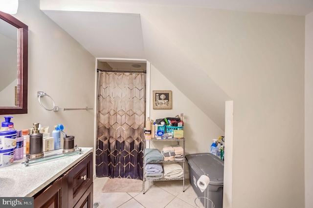 full bathroom with lofted ceiling, curtained shower, tile patterned flooring, and vanity