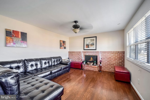 living room with a fireplace, wood finished floors, a ceiling fan, and baseboards