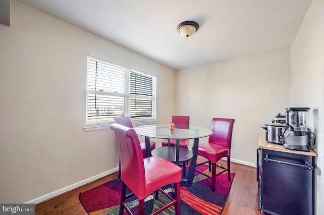 dining room featuring dark wood-type flooring and baseboards