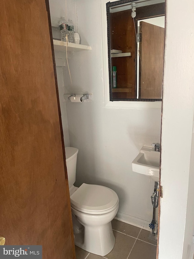 bathroom featuring tile patterned flooring, a sink, and toilet