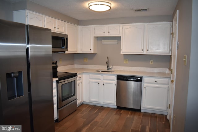 kitchen with appliances with stainless steel finishes, white cabinets, and a sink