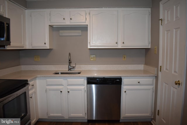 kitchen with stainless steel appliances, a sink, light countertops, and white cabinets