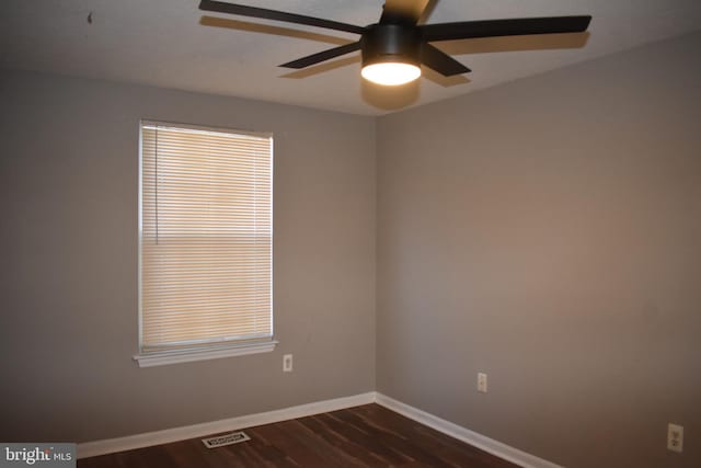 unfurnished room with a ceiling fan, baseboards, visible vents, and dark wood-style flooring