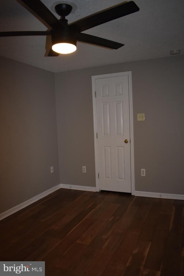 empty room with baseboards and dark wood-style flooring