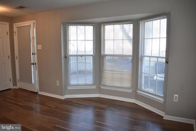 entrance foyer with wood finished floors, visible vents, and baseboards