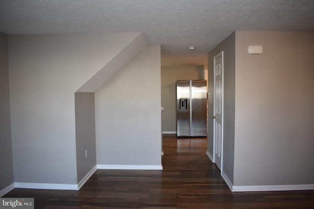 bonus room with a textured ceiling, wood finished floors, and baseboards