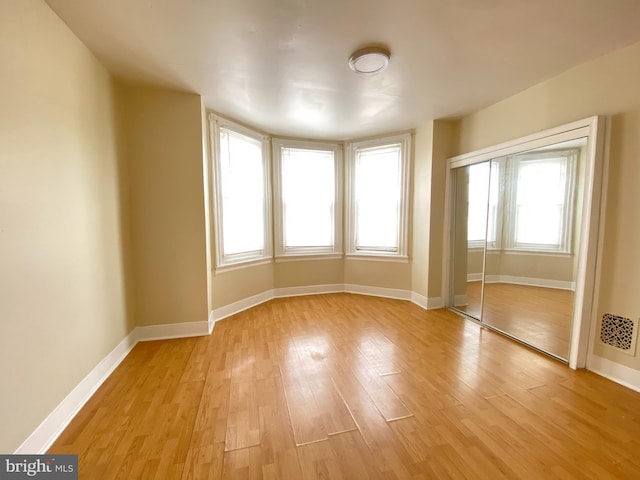 unfurnished room featuring light wood finished floors and baseboards