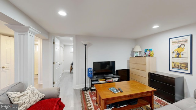 living room with baseboards, wood finished floors, decorative columns, and recessed lighting