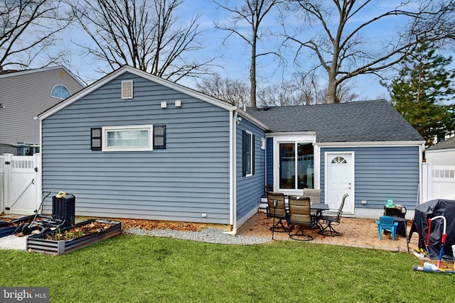 rear view of house with a yard, fence, a vegetable garden, and a patio