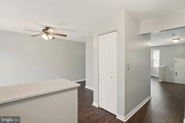 hall with dark wood-type flooring and baseboards