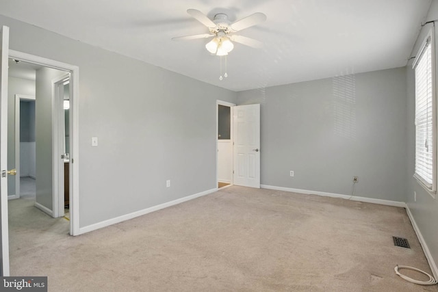 unfurnished bedroom with carpet flooring, baseboards, visible vents, and ceiling fan