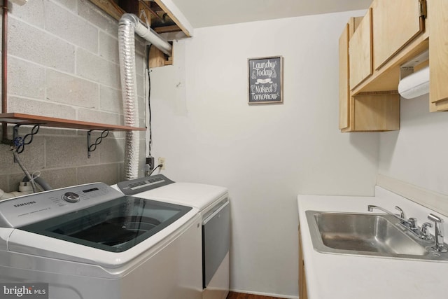 laundry room featuring separate washer and dryer, cabinet space, and a sink