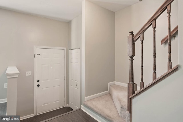 entryway with baseboards, dark wood-type flooring, and stairs