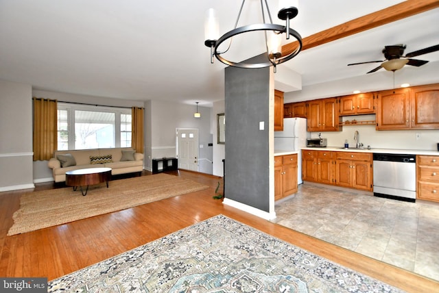 kitchen with light wood-style floors, stainless steel appliances, a sink, and light countertops