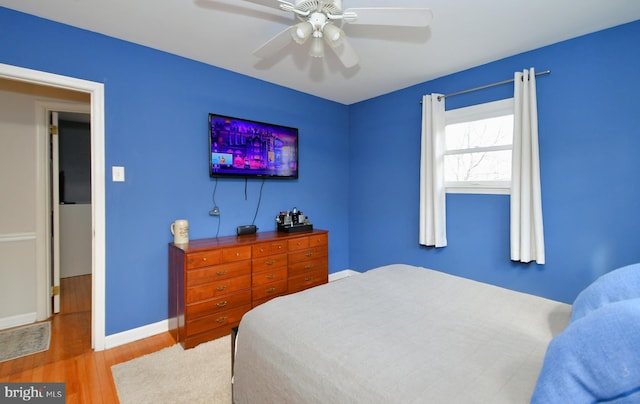 bedroom featuring wood finished floors, a ceiling fan, and baseboards