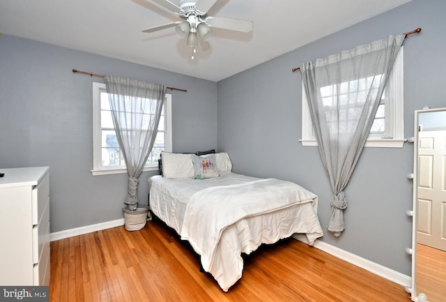 bedroom with light wood-style floors, ceiling fan, and baseboards