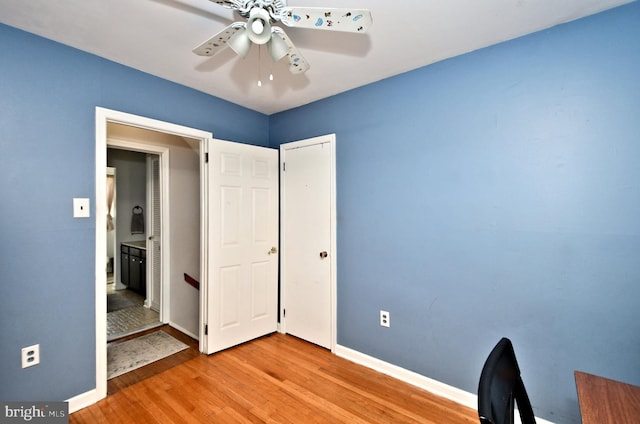 unfurnished office featuring baseboards, a ceiling fan, and wood finished floors