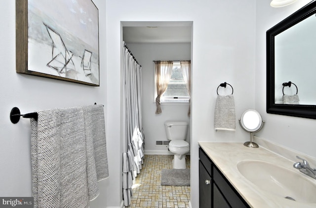 bathroom featuring visible vents, baseboards, toilet, a shower with curtain, and vanity