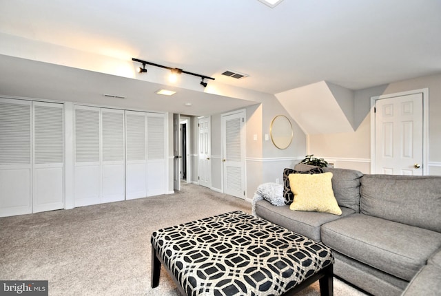 living area featuring visible vents, light carpet, and track lighting