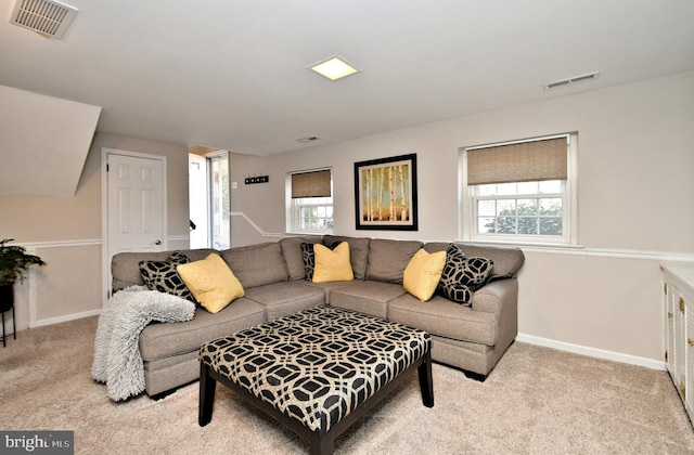 living area with carpet floors, a healthy amount of sunlight, and visible vents