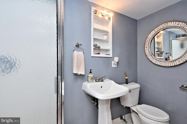 bathroom with built in shelves and toilet