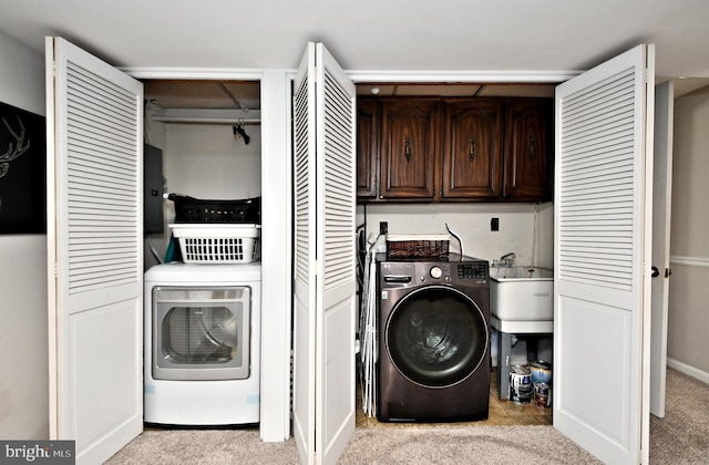 laundry area with carpet floors, washer / clothes dryer, and cabinet space