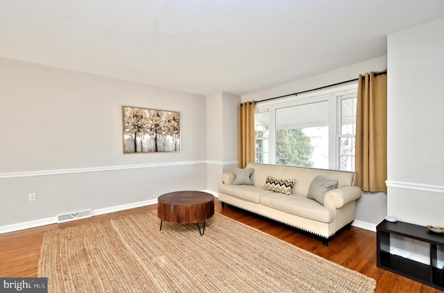 sitting room with visible vents, baseboards, and wood finished floors