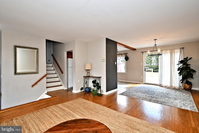 entryway featuring a chandelier, wood-type flooring, stairway, and baseboards