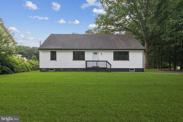 back of house with a yard and roof with shingles