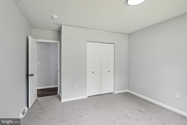 unfurnished bedroom with a closet, carpet flooring, and baseboards