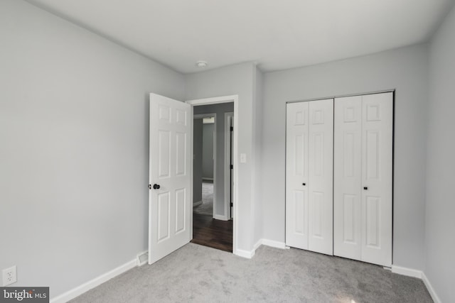 unfurnished bedroom featuring a closet, carpet, and baseboards