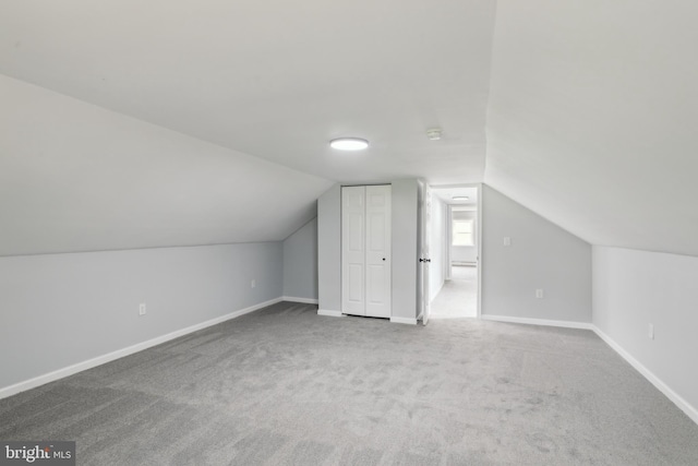 additional living space featuring vaulted ceiling, carpet, and baseboards