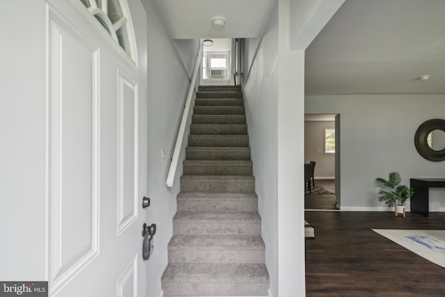 staircase with wood finished floors and baseboards