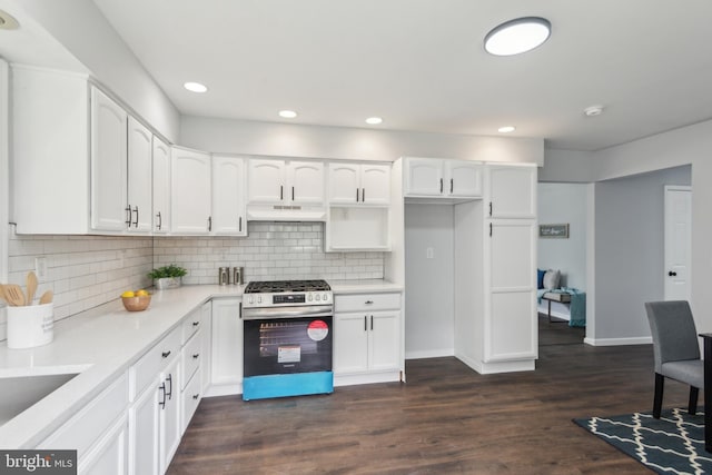 kitchen featuring gas range, dark wood-type flooring, under cabinet range hood, white cabinetry, and backsplash