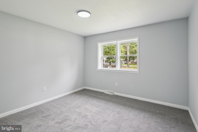 carpeted spare room featuring visible vents and baseboards