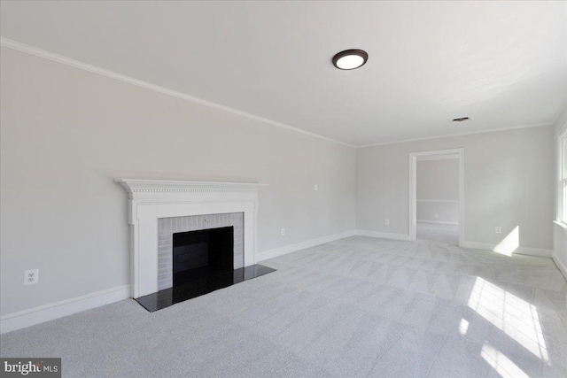 unfurnished living room featuring a brick fireplace, baseboards, crown molding, and carpet flooring