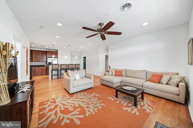 living area with recessed lighting, visible vents, and light wood-style floors