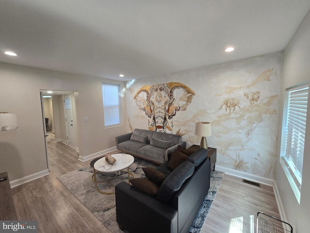 living area with recessed lighting, visible vents, baseboards, and wood finished floors