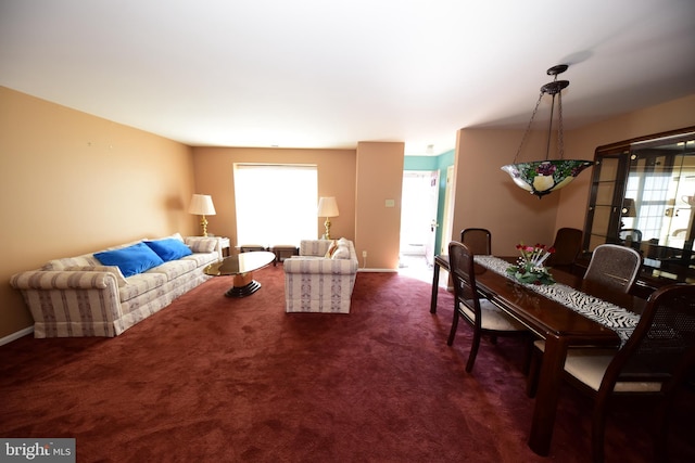 living area featuring dark colored carpet and baseboards