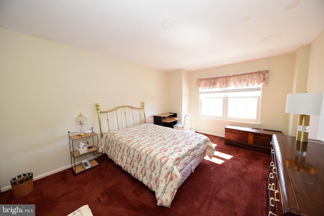 bedroom featuring dark carpet and baseboards