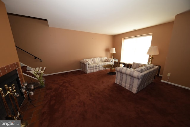 living area featuring a tile fireplace, carpet flooring, and baseboards