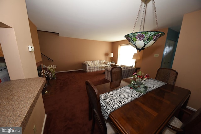 dining room featuring carpet floors, stairway, and baseboards