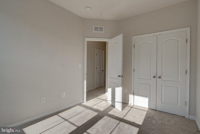 unfurnished bedroom with a closet, visible vents, baseboards, and carpet flooring