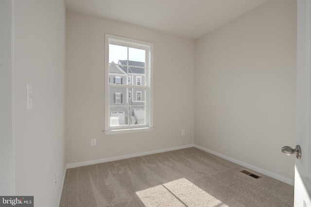 carpeted spare room with baseboards and visible vents