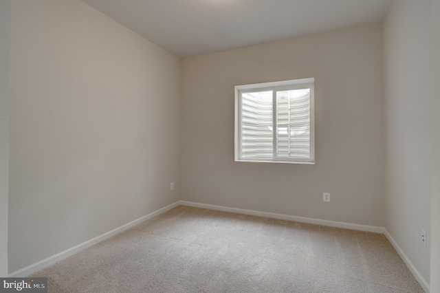 carpeted spare room featuring baseboards